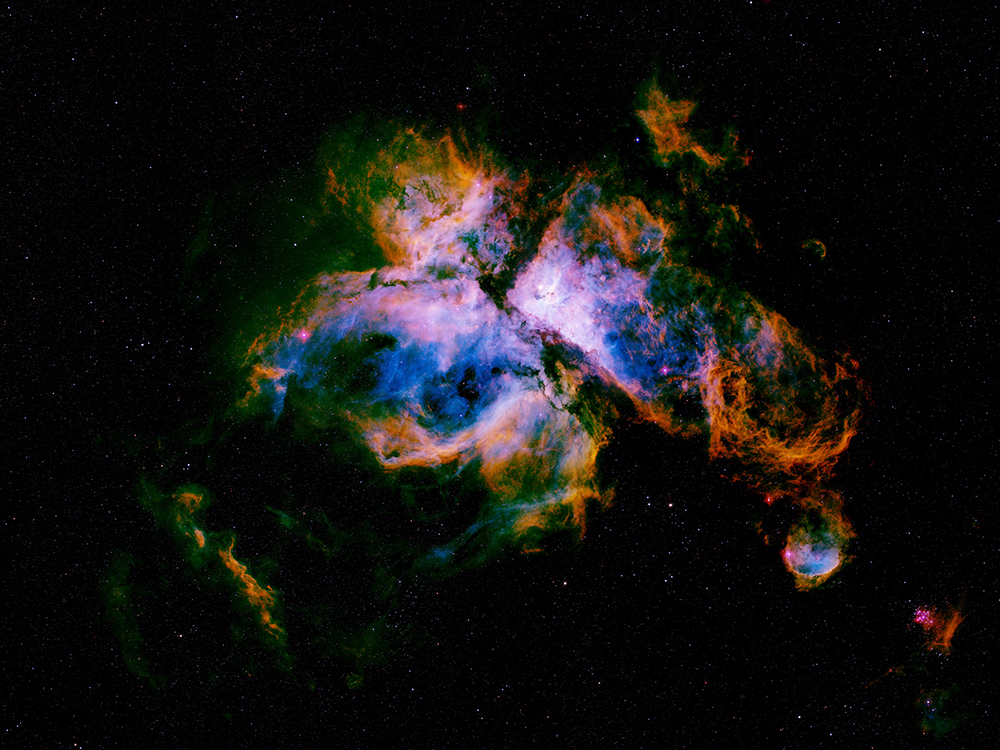 A wide mosaic of the Carina Nebula rendered in vivid blue, gold and violet
