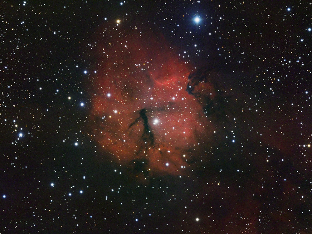 Gum 15 emission nebula with dark dust lanes and glowing hydrogen clouds