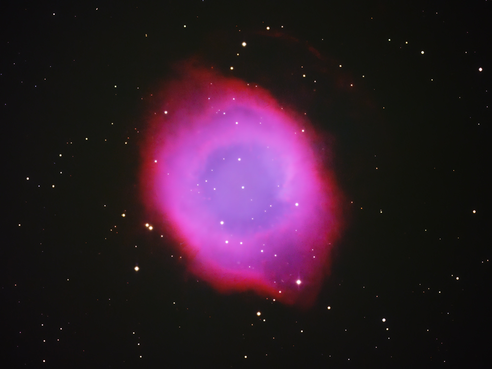 The Helix Nebula appearing as a blue and red eye against a field of stars