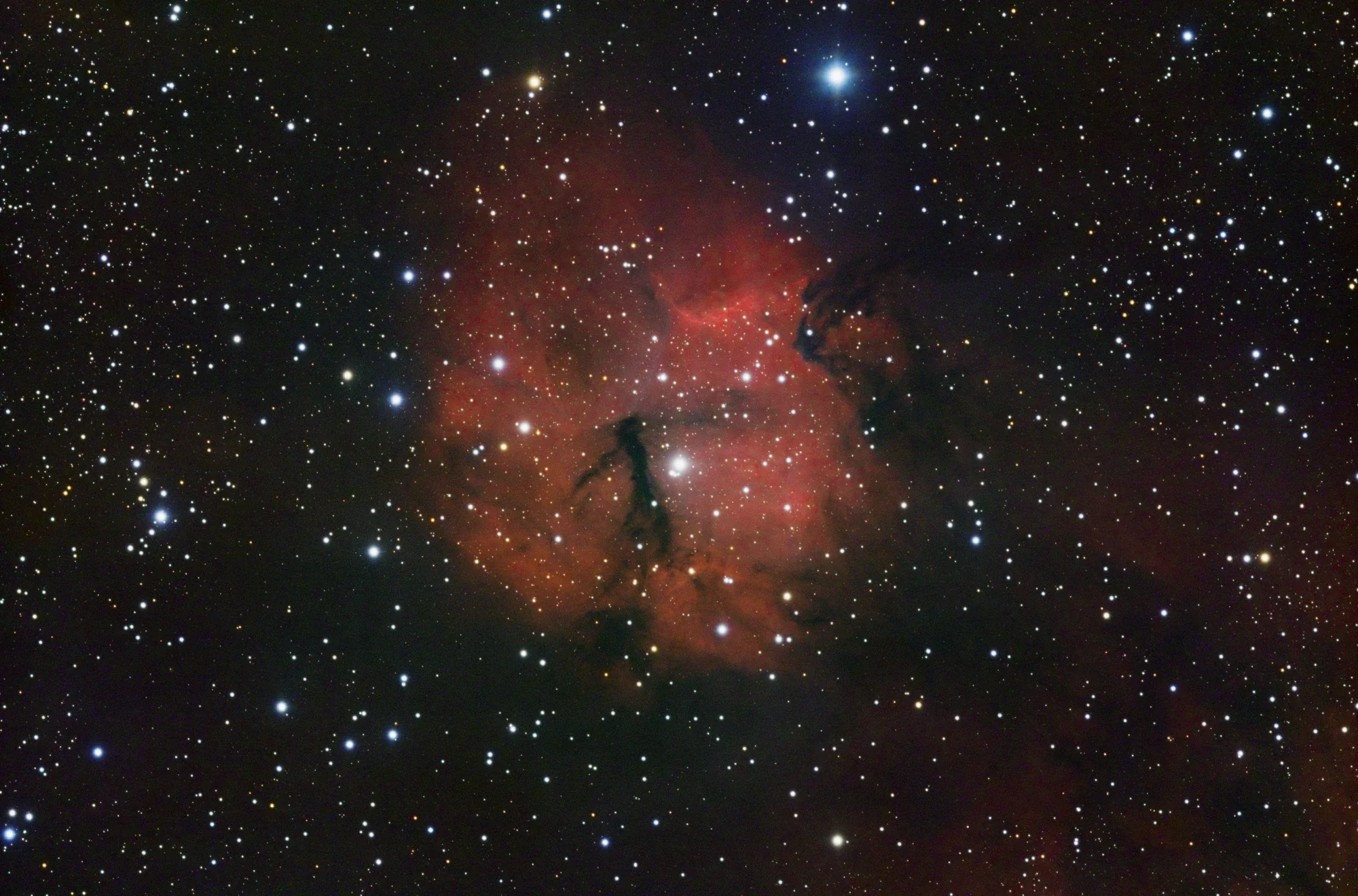 Gum 15 emission nebula with dark dust lanes and glowing hydrogen clouds