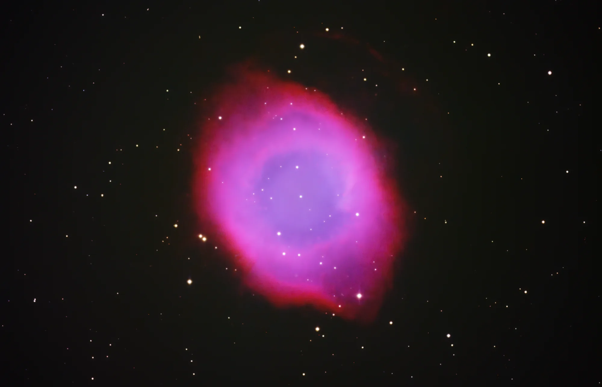 The Helix Nebula appearing as a blue and red eye against a field of stars